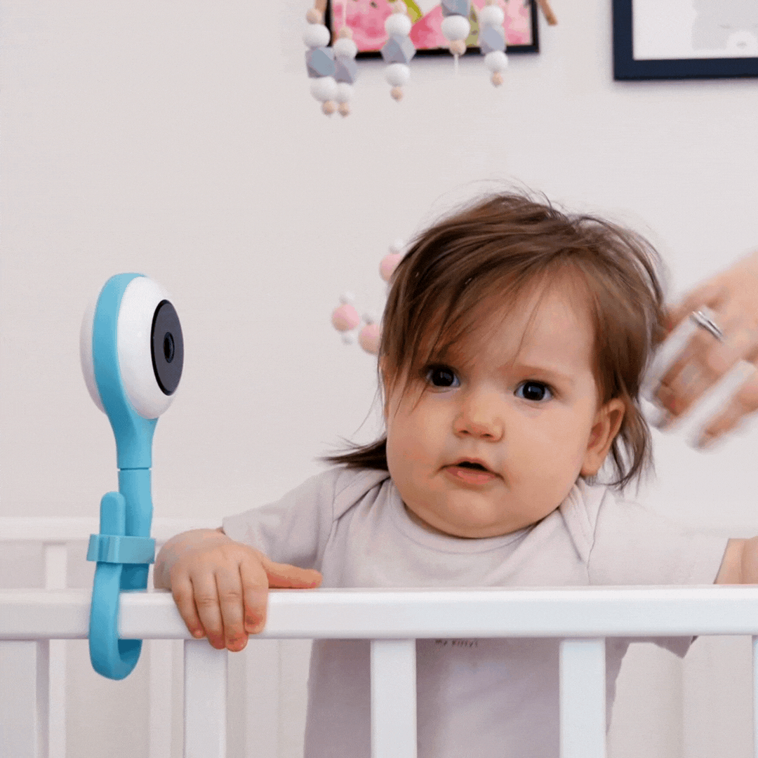 A baby playing on her crib.